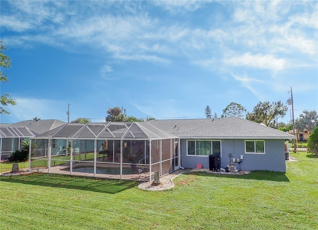 back of property with a pool, a yard, and a lanai