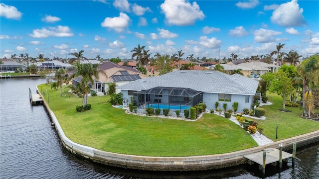 back of house with glass enclosure, a lawn, and a water view