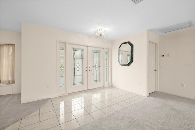 unfurnished room with light colored carpet and french doors