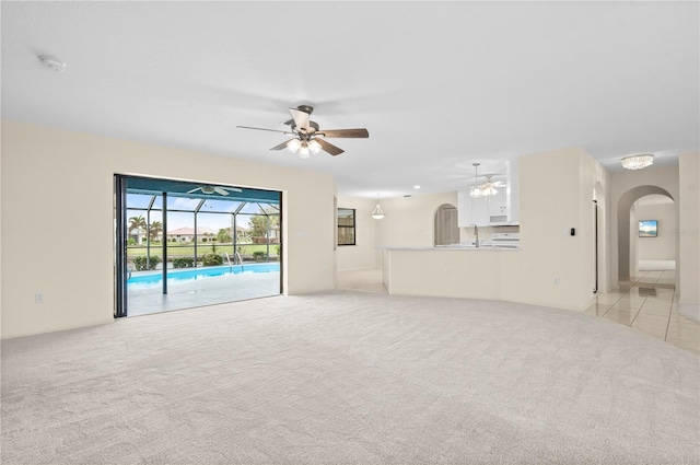 unfurnished living room with light carpet and ceiling fan