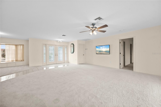 carpeted empty room featuring ceiling fan, french doors, and a healthy amount of sunlight