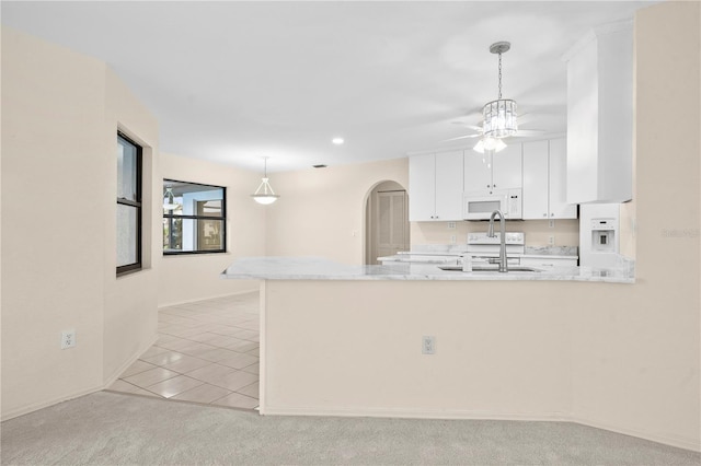 kitchen featuring ceiling fan, white appliances, white cabinets, and kitchen peninsula