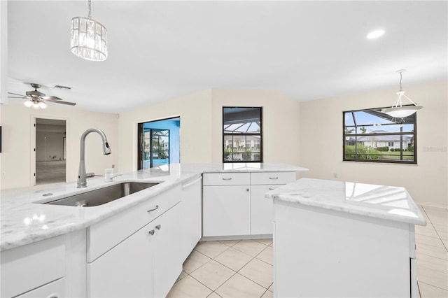 kitchen with sink, a kitchen island, white cabinetry, and plenty of natural light