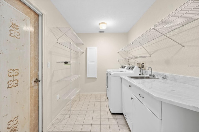 laundry room featuring sink, independent washer and dryer, cabinets, and light tile patterned floors