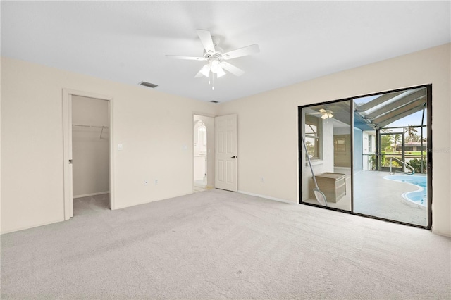 empty room featuring ceiling fan, lofted ceiling, and light carpet