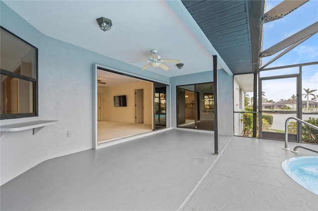 unfurnished sunroom featuring ceiling fan