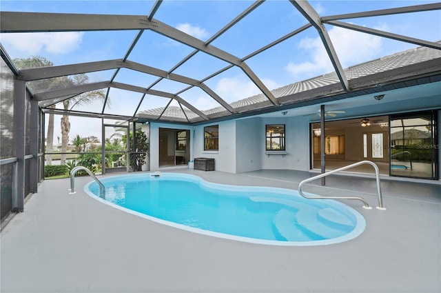 view of swimming pool featuring a patio, glass enclosure, and ceiling fan