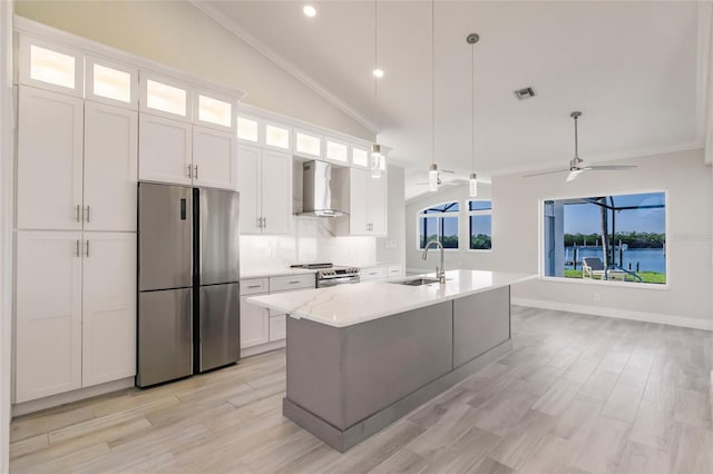 17183 Ohara Dr, Port Charlotte, FL 33948 - kitchen featuring stainless steel appliances, wall chimney range hood, a sink, vaulted ceiling, and an island with sink