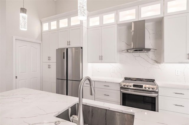 17183 Ohara Dr, Port Charlotte, FL 33948 - kitchen with stainless steel appliances, wall chimney exhaust hood, decorative light fixtures, and white cabinetry