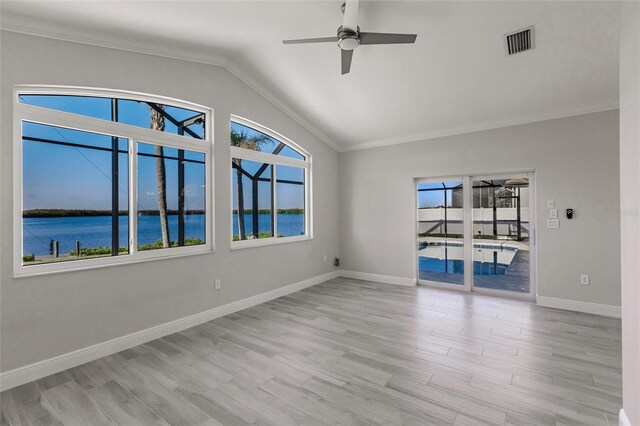 17183 Ohara Dr, Port Charlotte, FL 33948 - spare room featuring vaulted ceiling, a ceiling fan, wood finished floors, crown molding, and a water view
