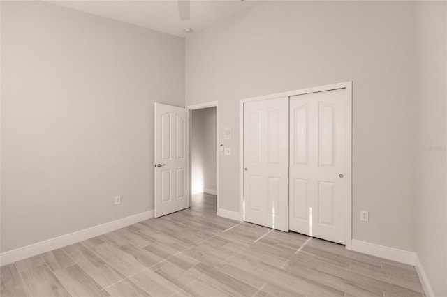 17183 Ohara Dr, Port Charlotte, FL 33948 - unfurnished bedroom featuring baseboards, a closet, a high ceiling, light wood-type flooring, and ceiling fan