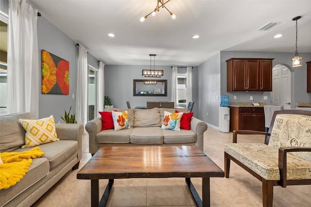 tiled living room featuring a notable chandelier