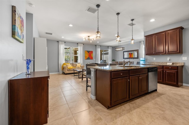 kitchen featuring sink, hanging light fixtures, stainless steel dishwasher, light stone countertops, and a kitchen island with sink