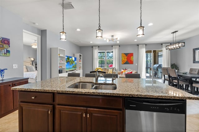 kitchen with dark brown cabinetry, sink, stainless steel dishwasher, and a center island with sink