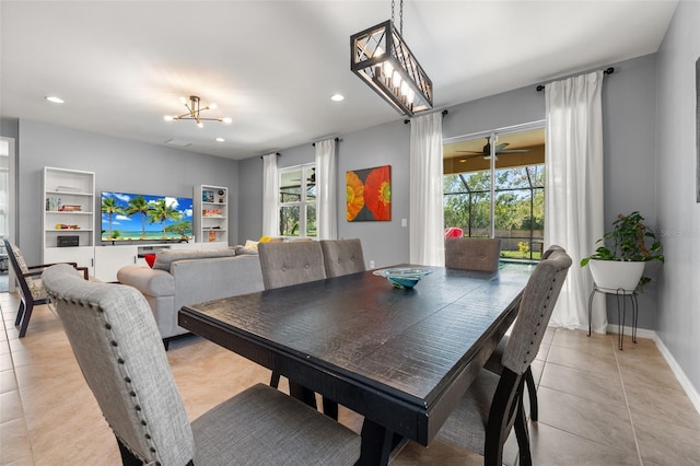 dining area with light tile patterned flooring and ceiling fan with notable chandelier