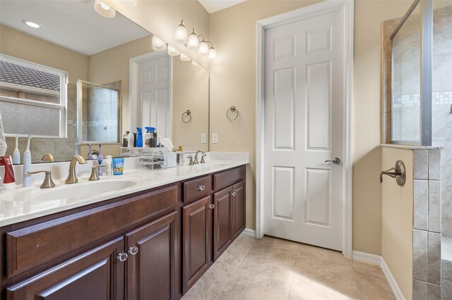 bathroom featuring vanity, a tile shower, and tile patterned floors