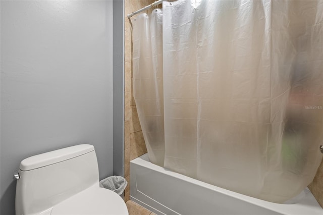 bathroom with shower / tub combo with curtain and toilet