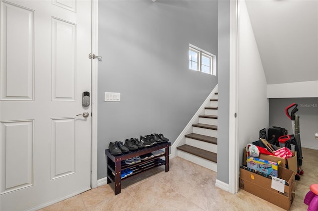 interior space with lofted ceiling and light tile patterned flooring