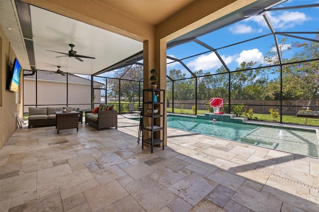 view of swimming pool with ceiling fan, a patio, an outdoor hangout area, and glass enclosure