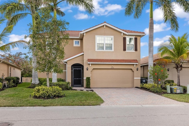 mediterranean / spanish-style house featuring a garage and a front yard