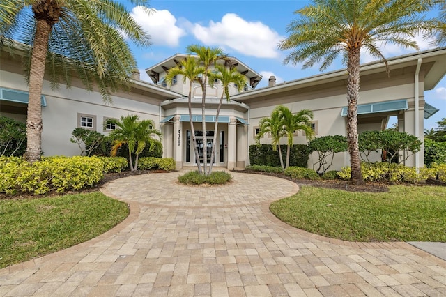 view of front of house featuring a front lawn and french doors