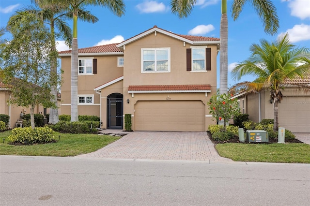 mediterranean / spanish-style home with a garage and a front lawn