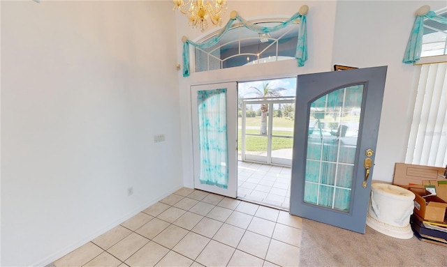 tiled entrance foyer with a high ceiling and a wealth of natural light