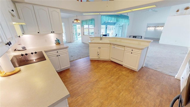 kitchen with hanging light fixtures, white dishwasher, light colored carpet, black electric cooktop, and white cabinets