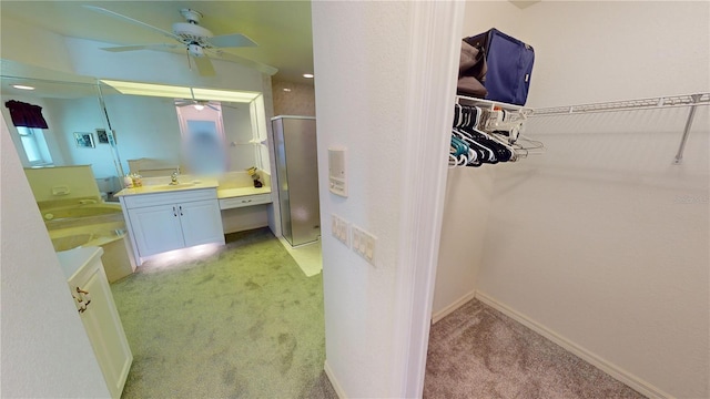 bathroom with ceiling fan, walk in shower, and vanity