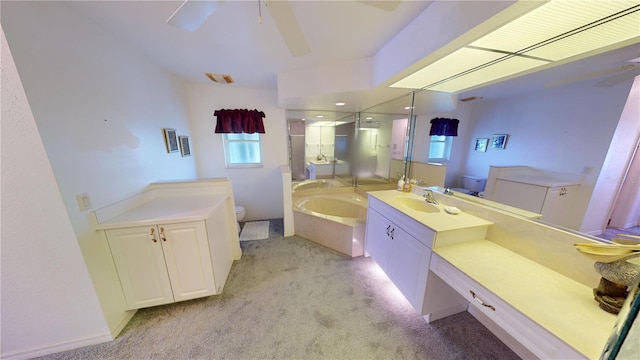 bathroom featuring a bathing tub, ceiling fan, vanity, and toilet