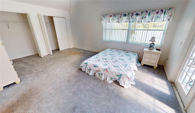 carpeted bedroom with two closets and multiple windows