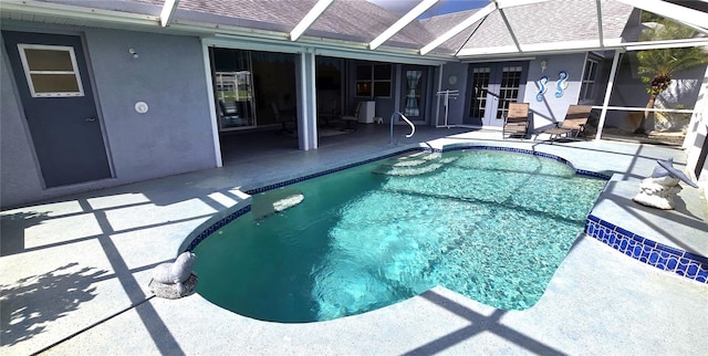 view of pool with french doors, a patio, and glass enclosure