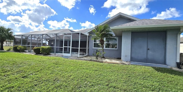 back of house with a lawn and glass enclosure