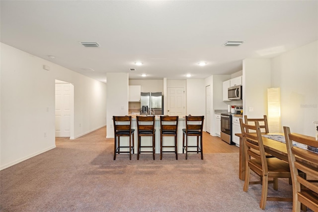 dining space featuring light colored carpet