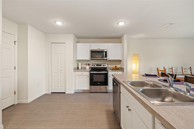 kitchen featuring sink, white cabinets, and appliances with stainless steel finishes