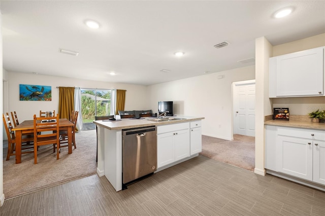 kitchen with white cabinetry, dishwasher, light carpet, and sink