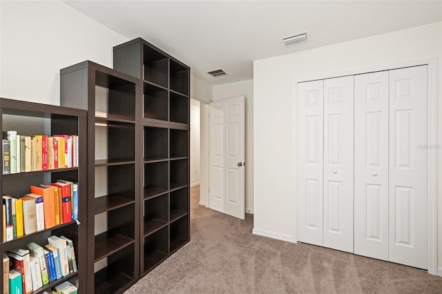 unfurnished bedroom featuring light carpet and a closet