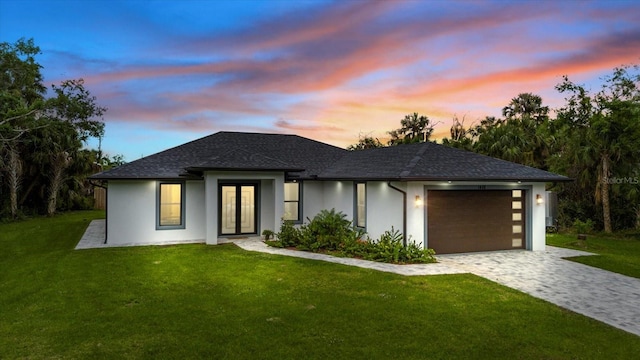 prairie-style house featuring a yard and a garage