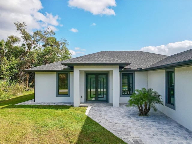 back of property with a yard and french doors