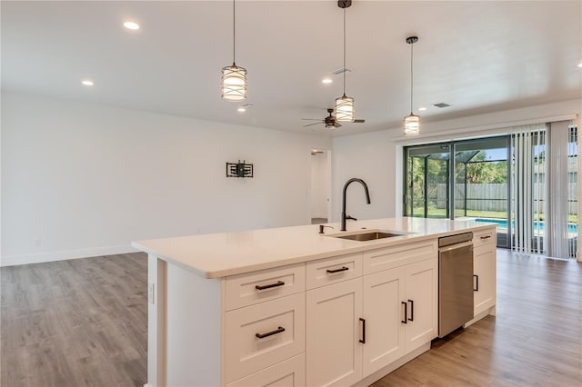 kitchen featuring a center island with sink, white cabinetry, sink, and light hardwood / wood-style flooring