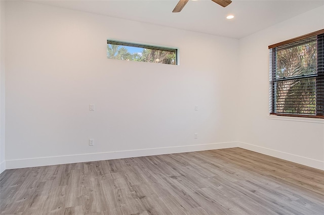 empty room with light hardwood / wood-style floors, ceiling fan, and a healthy amount of sunlight