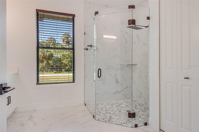 bathroom featuring a shower with shower door and a healthy amount of sunlight