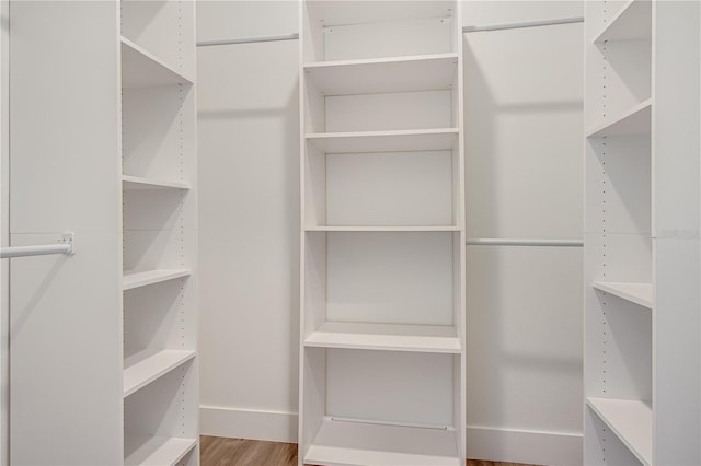 walk in closet with hardwood / wood-style floors