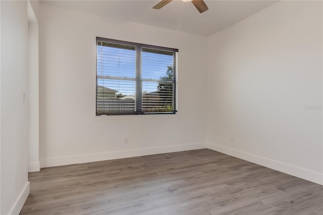 empty room with ceiling fan and light hardwood / wood-style flooring