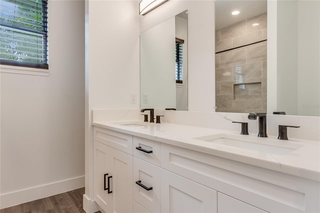 bathroom featuring tiled shower, vanity, and hardwood / wood-style flooring