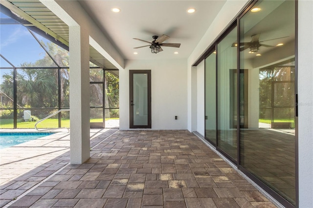 unfurnished sunroom featuring ceiling fan and a pool