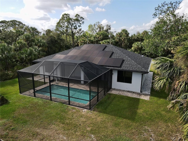 back of house with a lawn and glass enclosure