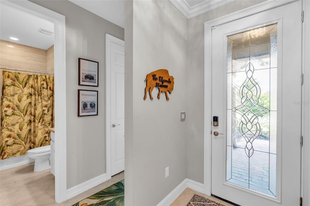 foyer entrance with a healthy amount of sunlight, light tile patterned floors, and ornamental molding