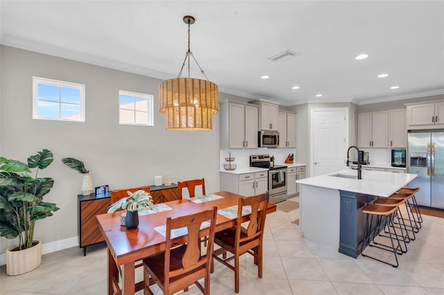 tiled dining area featuring crown molding, sink, and a notable chandelier