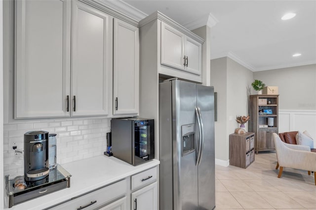 kitchen featuring backsplash, stainless steel refrigerator with ice dispenser, ornamental molding, light tile patterned flooring, and white cabinetry